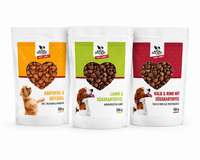 Drei DOGS-HEART Futterproben à 500 g auf weißem Hintergrund: Kartoffel & Geflügel, Lamm & Süßkartoffel sowie Kalb & Rind mit Süßkartoffel.