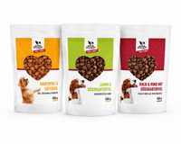 Drei DOGS-HEART Futterproben à 500 g auf weißem Hintergrund: Kartoffel & Geflügel, Lamm & Süßkartoffel sowie Kalb & Rind mit Süßkartoffel.